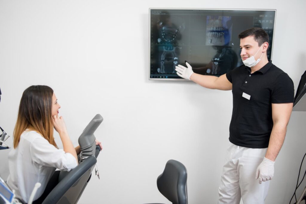 Dentist showing dental x-ray to patient